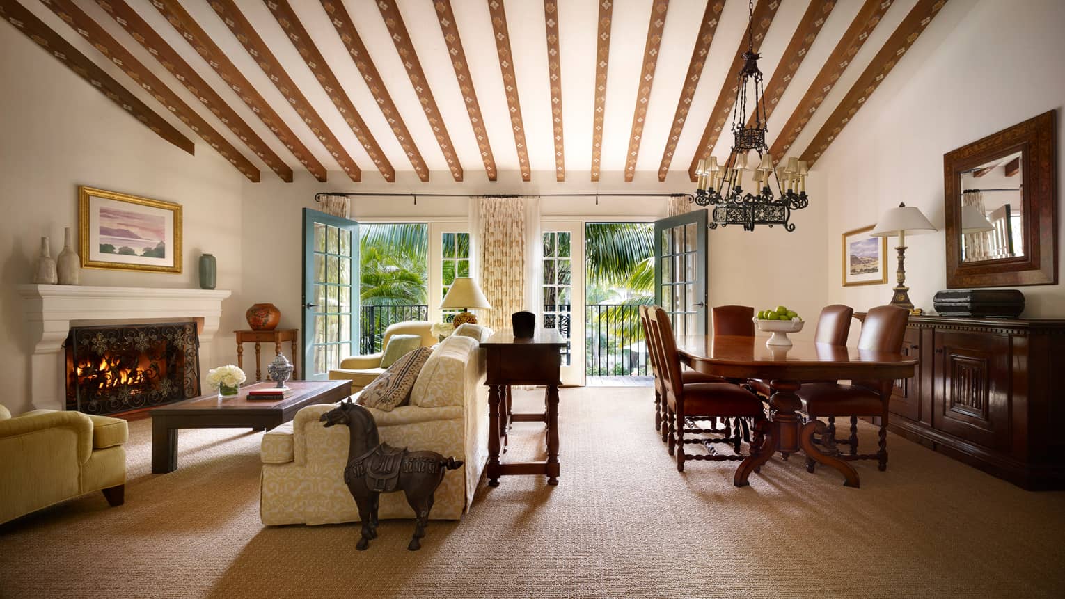 San Miguel Suite horse statue, seating area by fireplace, dining table under painted beams