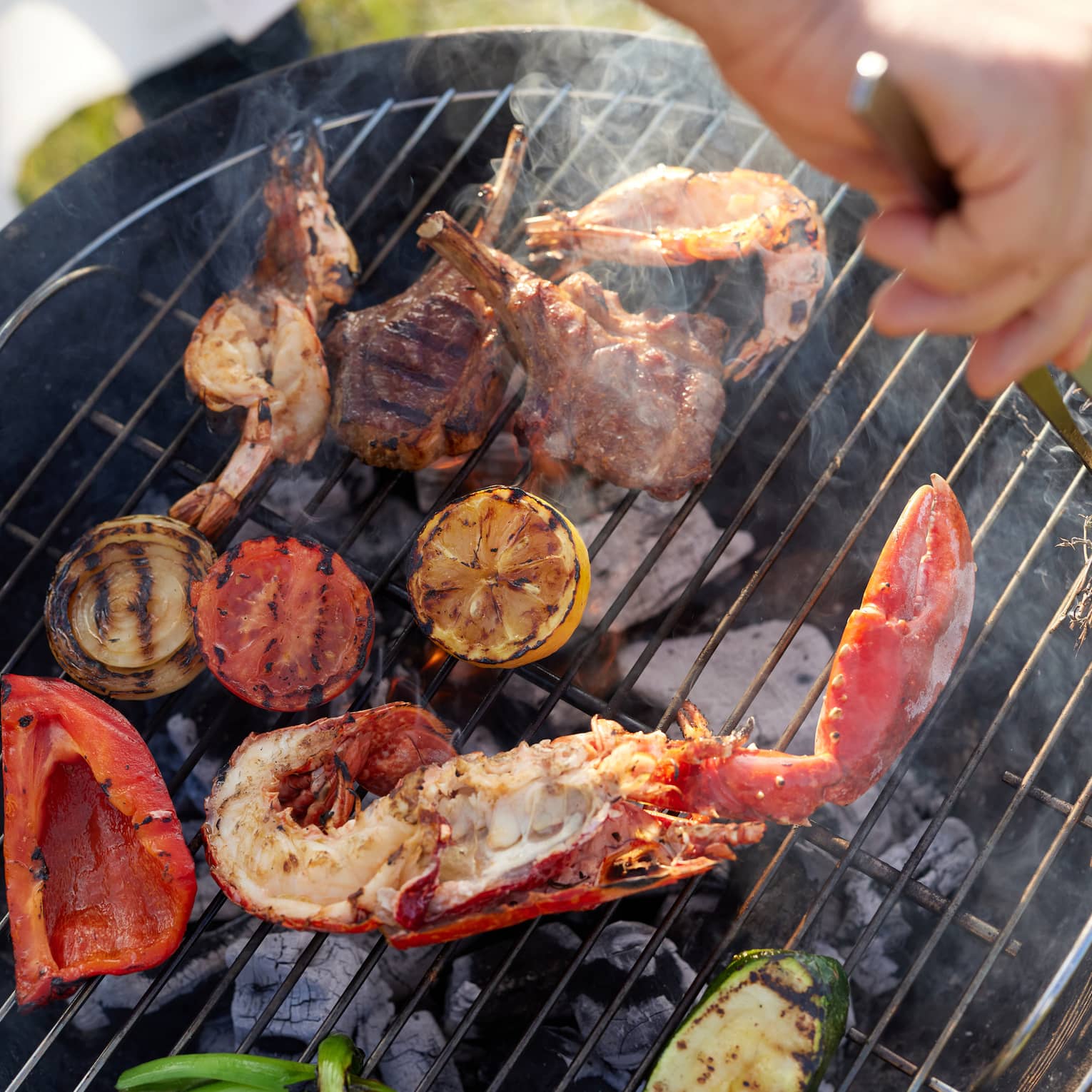 Seafood, lamb and vegetables cooking on a charcoal grill