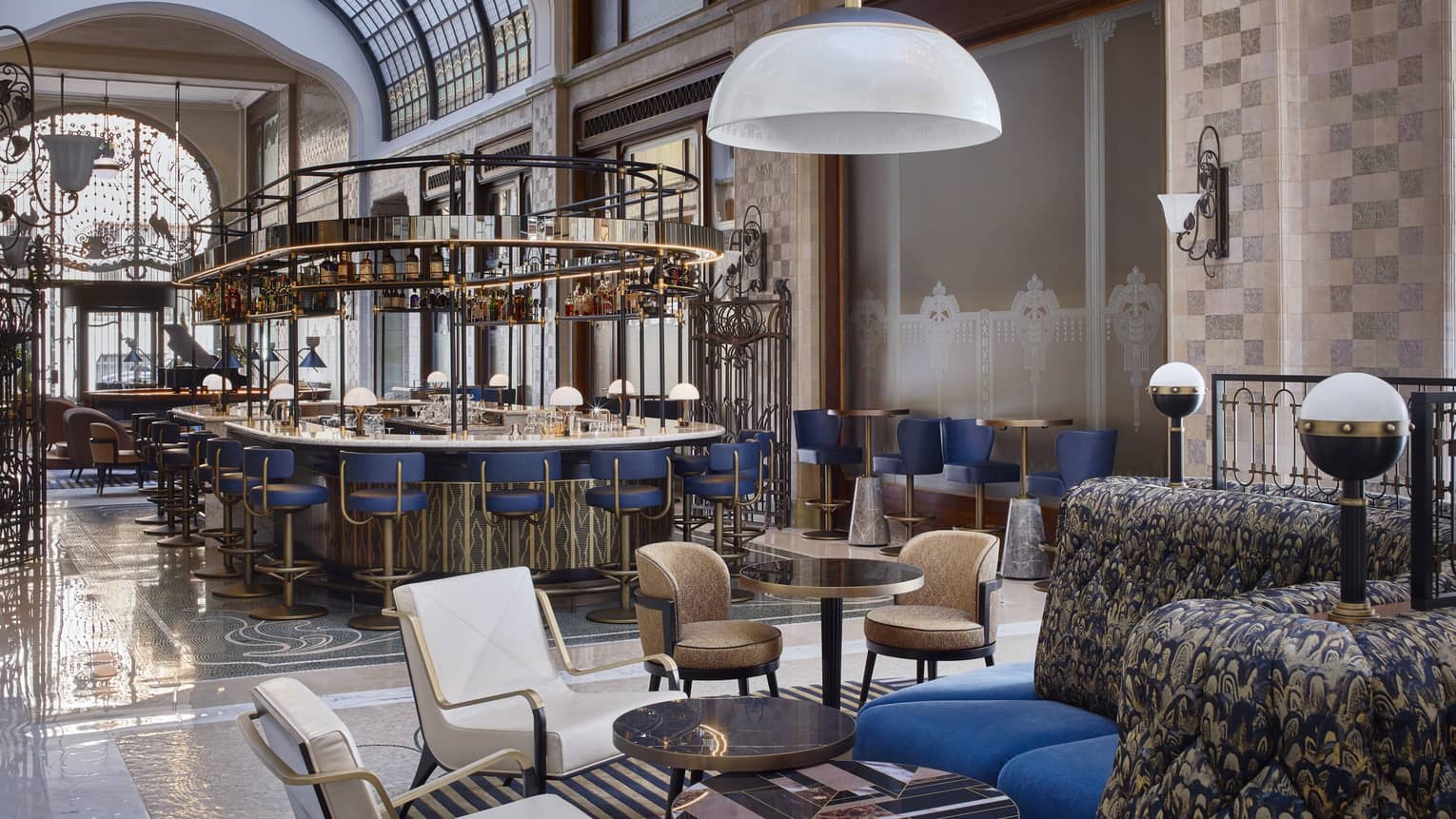 Modern white or brown leather chair pairs, blue banquettes in bar lounge, bar in backdrop