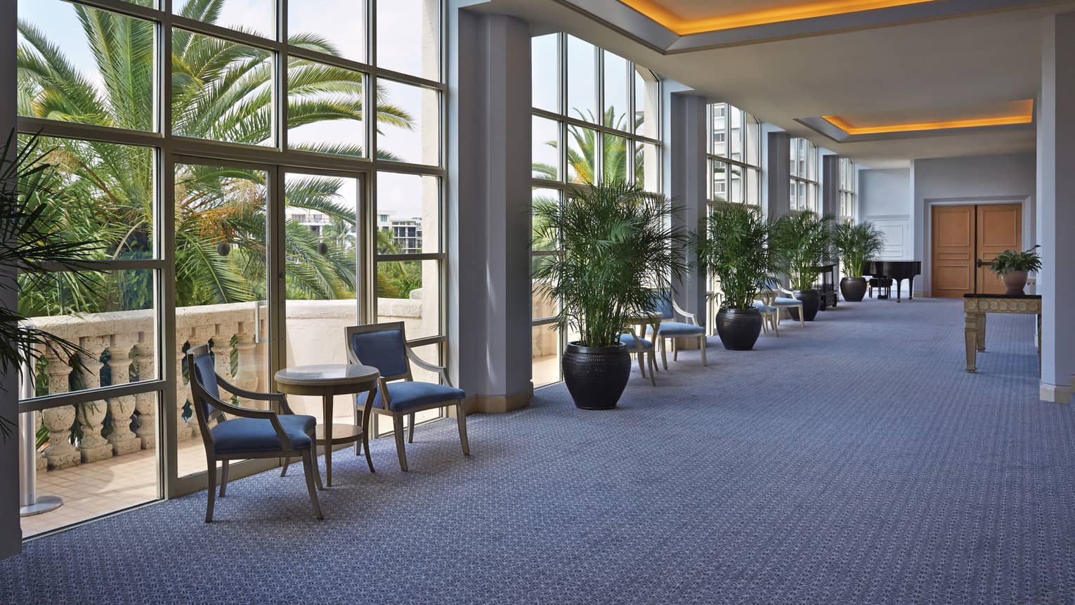 Royal Poinciana ballroom foyer with floor-to-ceiling loft windows, orange lights along ceiling