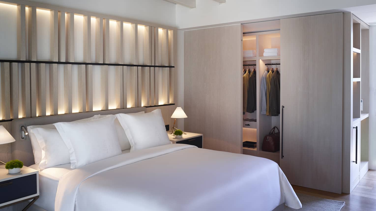 Bungalow Sea View with white king bed, backlit wall, closet with sliding wooden doors, exposed rafter ceiling, ceiling fan