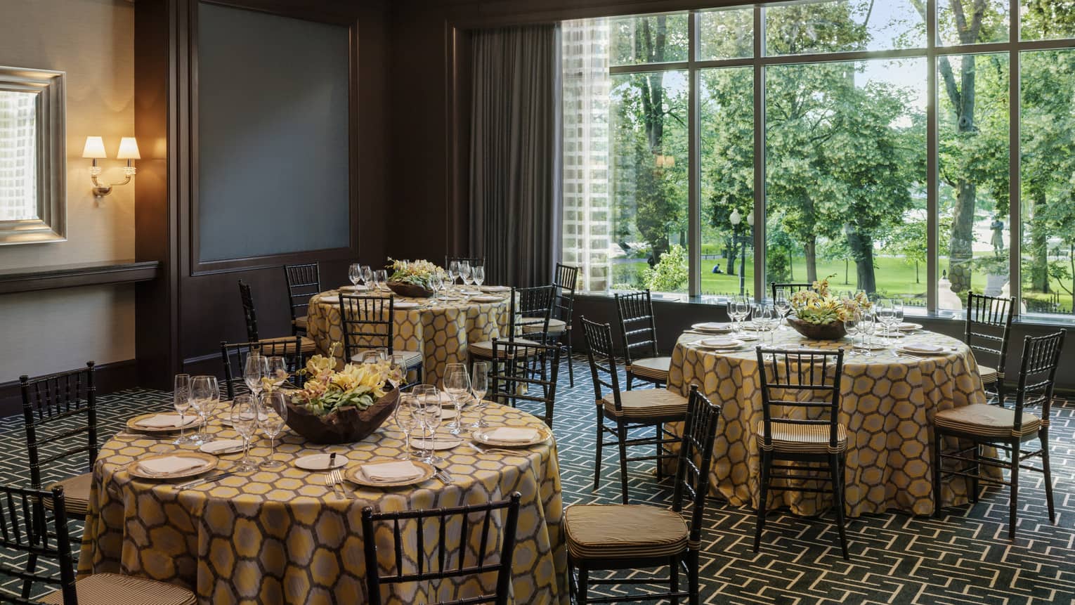 Round tables with patterned linens, large window in Stuart event room