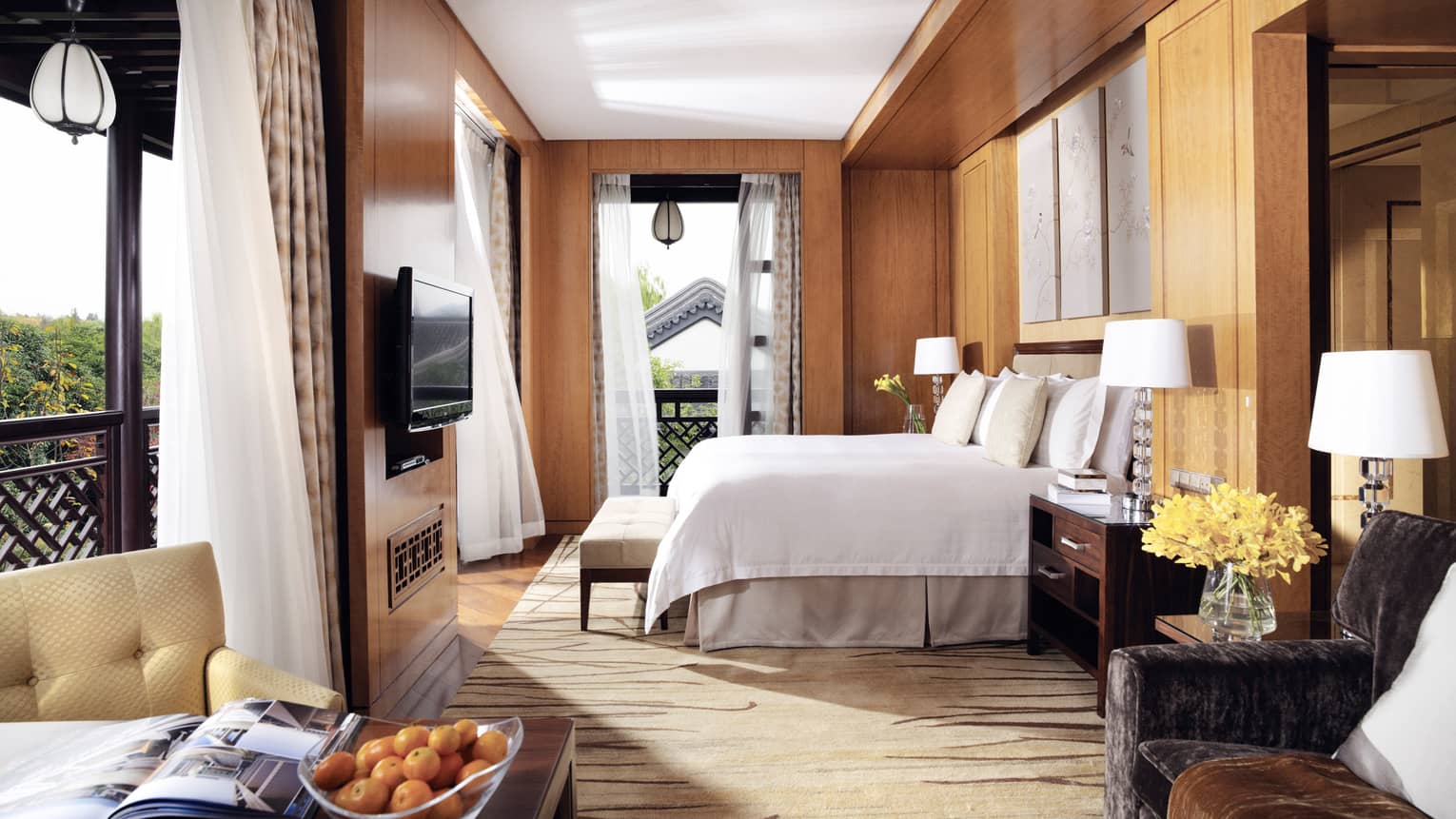 Executive Grand Premier room bed by open corner windows with sheer white curtains