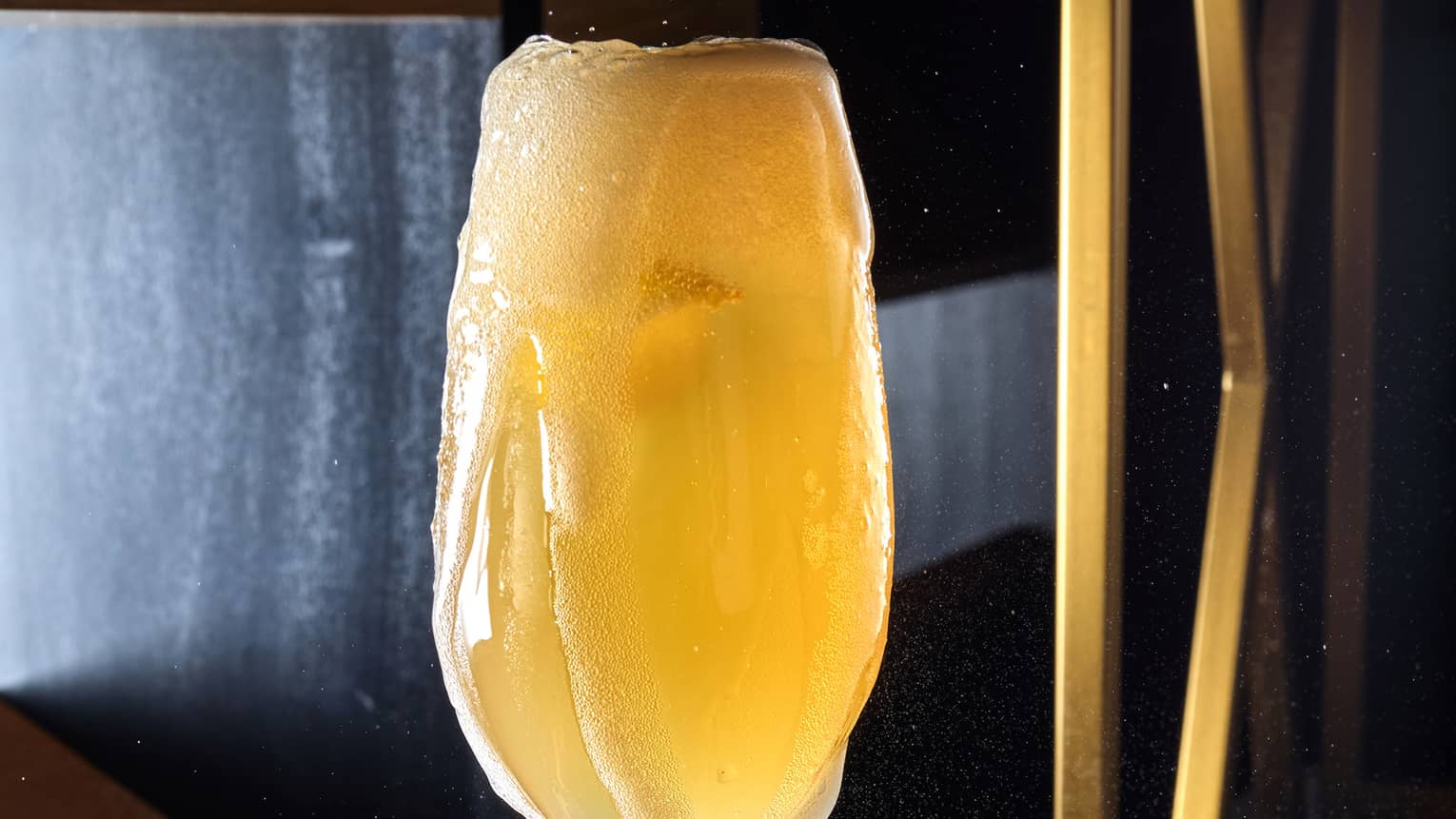 A champagne glass being filled with a drink
