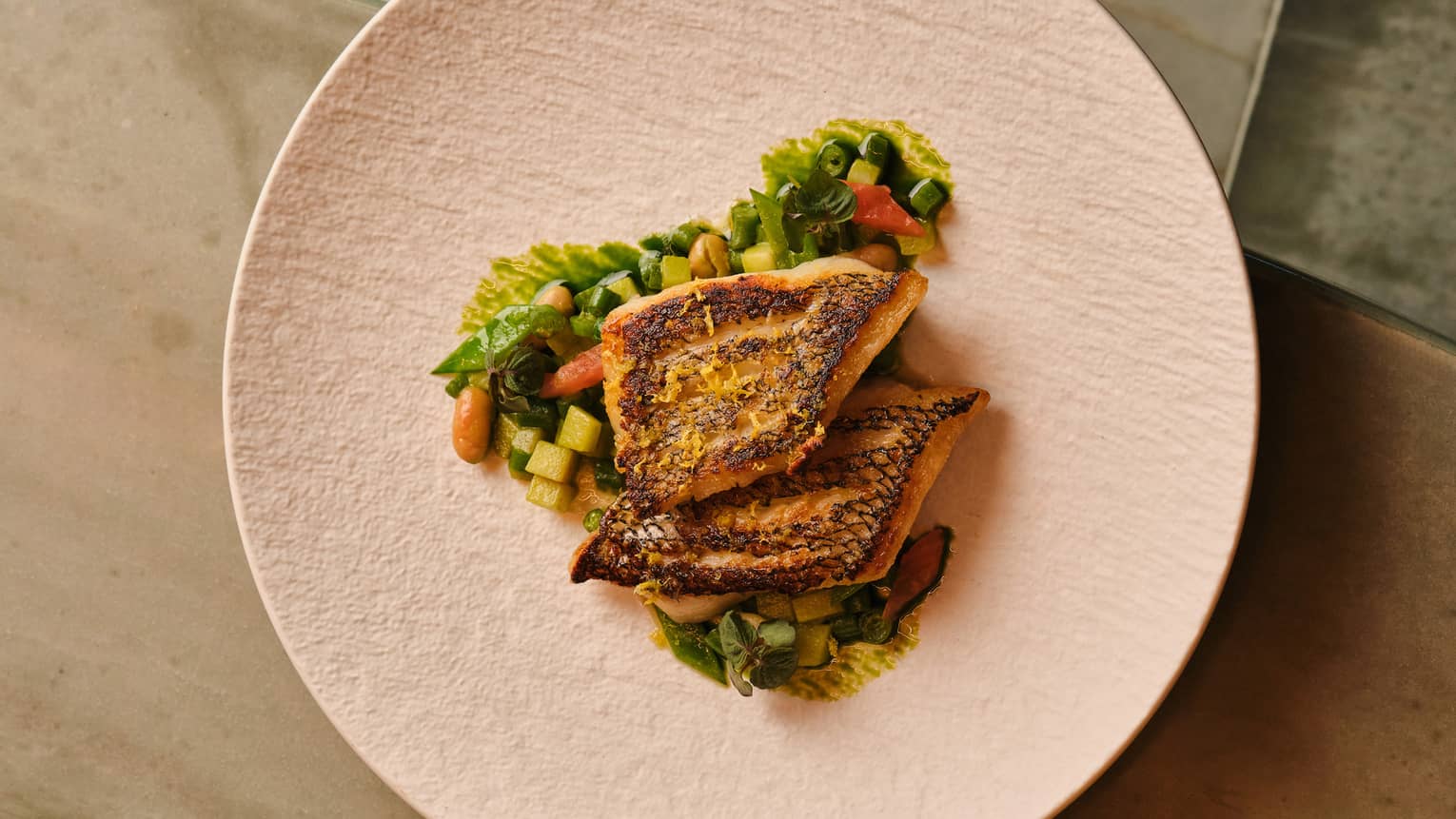 Sea bass with potatoes and greens on a plate