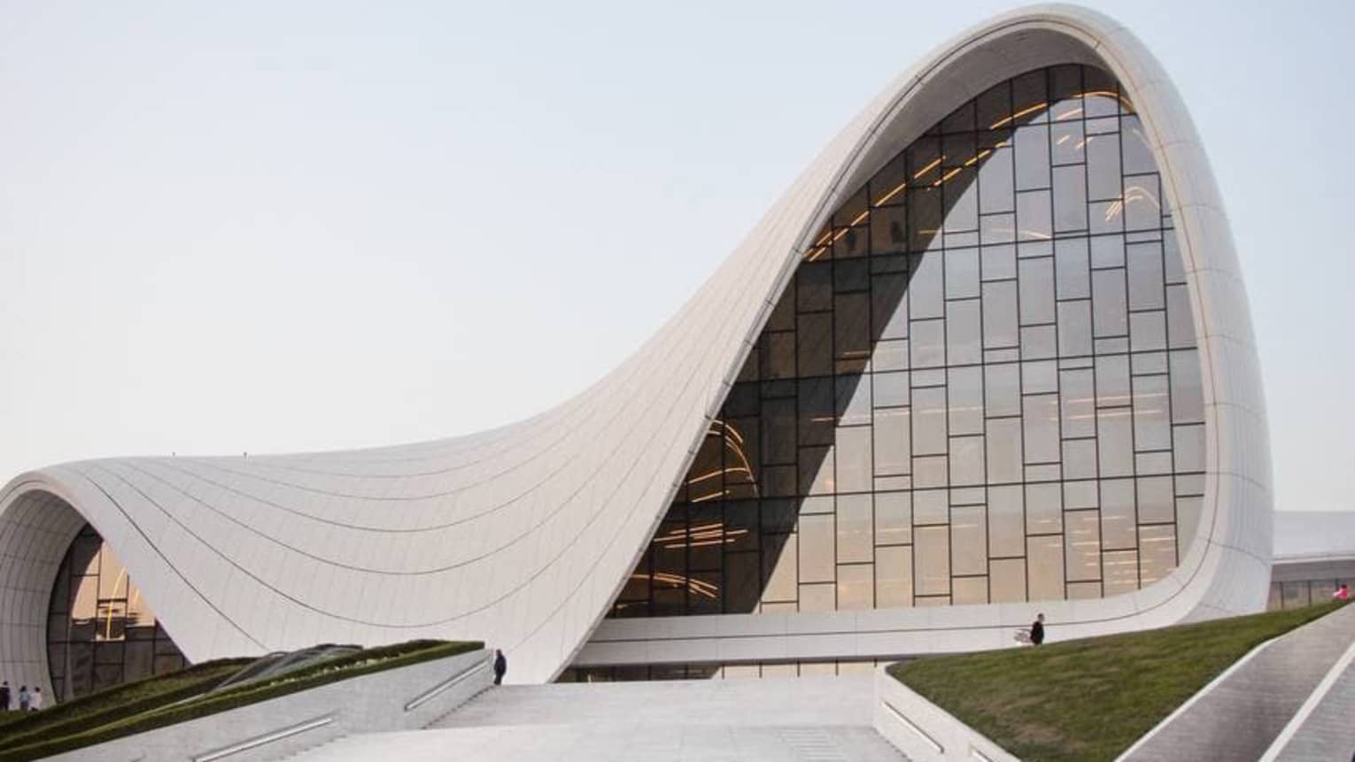 Concrete path leading up to Heydar Aliyev Center concrete building with arced shape