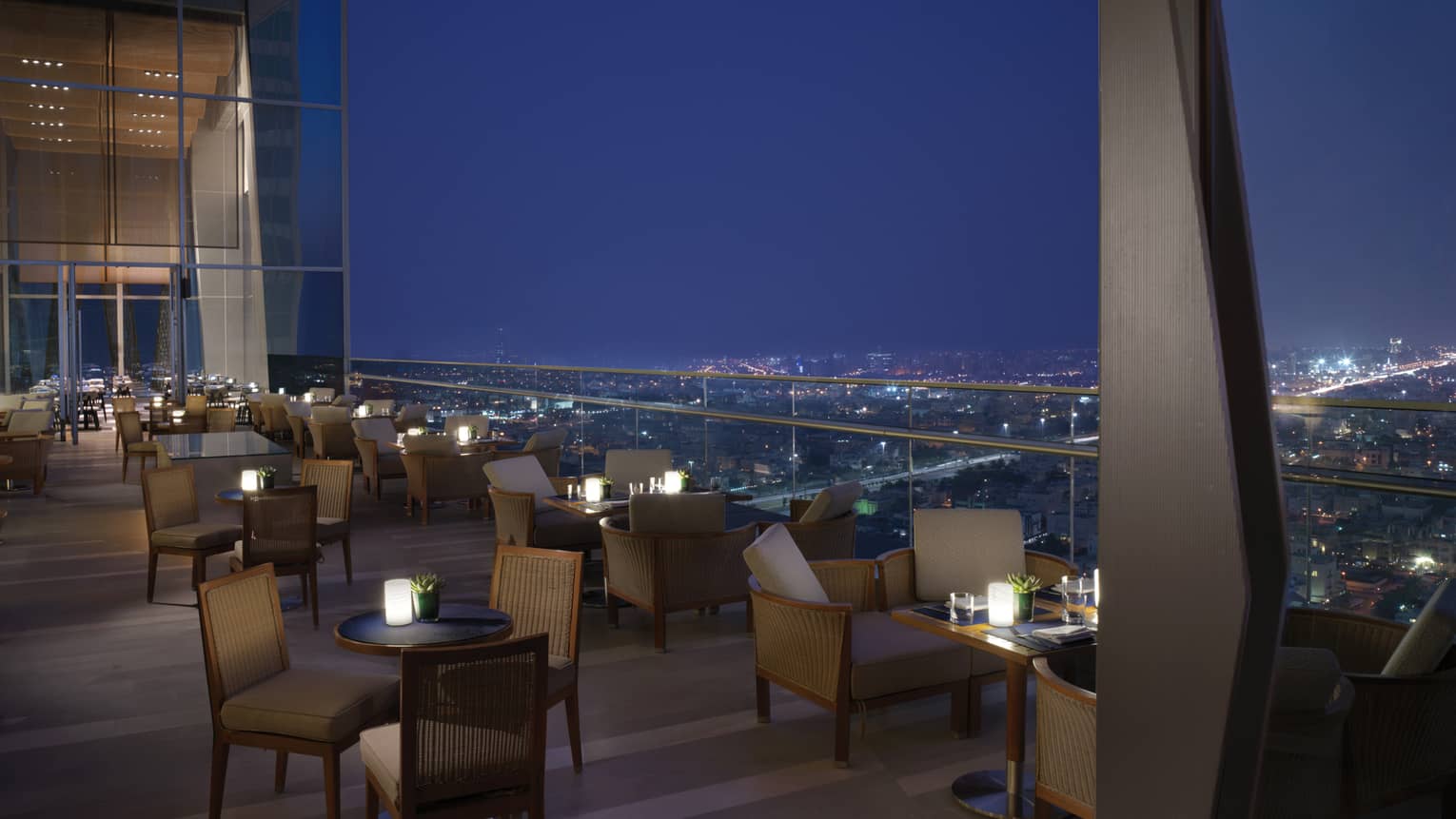 Several tables set up on the outdoor terrace overlooking Kuwait