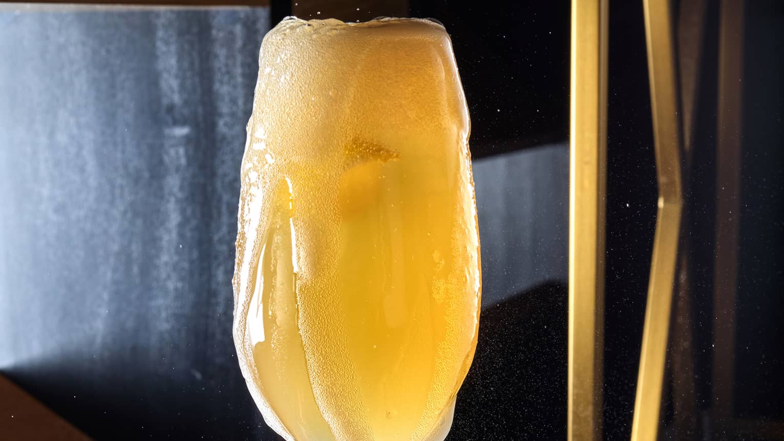 A champagne glass being filled with a drink