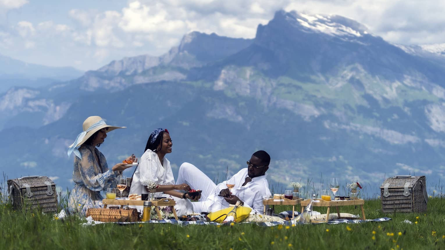 Three people enjoy a gourmet picnic in the mountains of Meg�ve, France