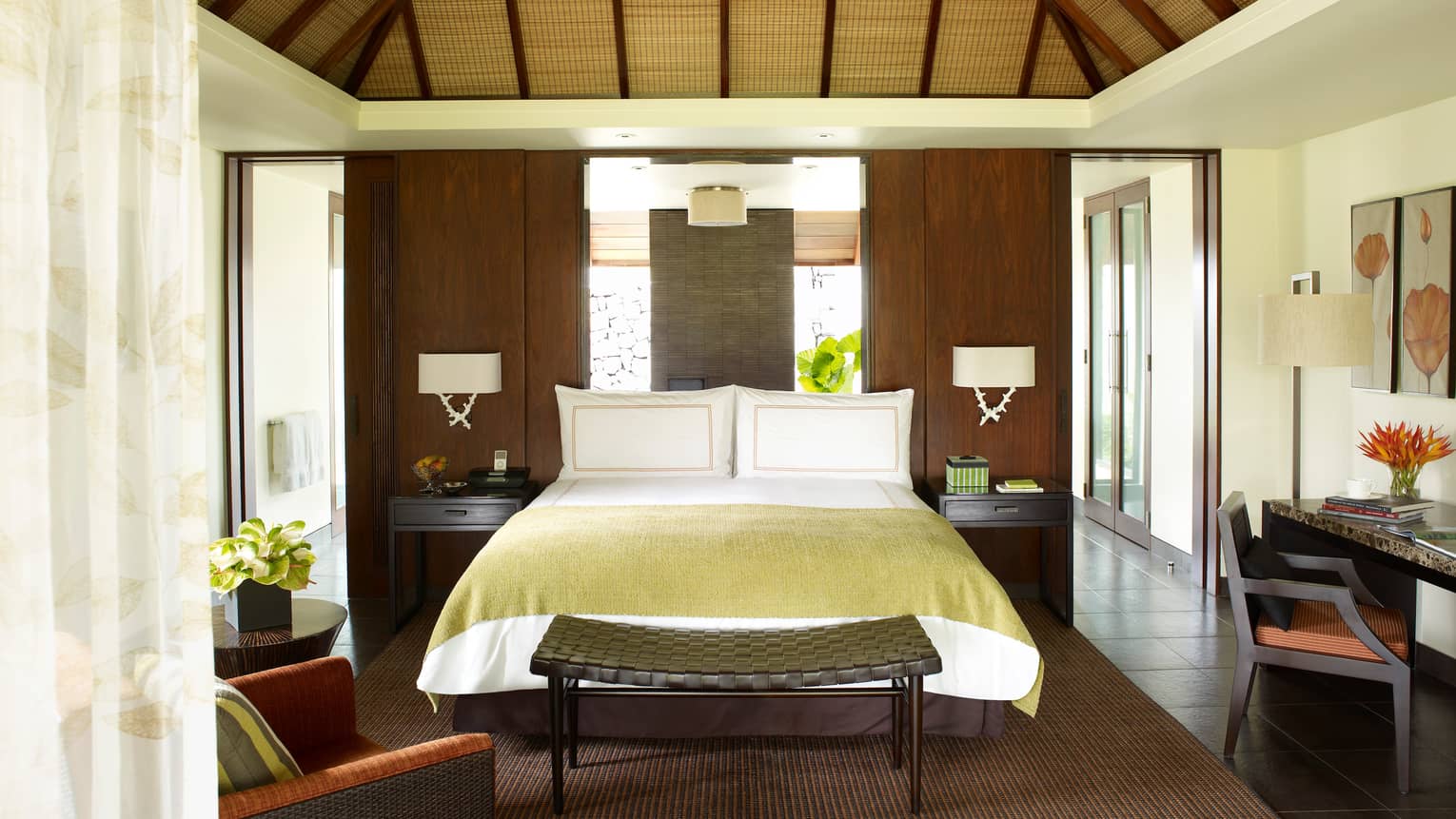 Mangrove Pool Villa bed with gold blanket, mirror headboard, dark wicker bench