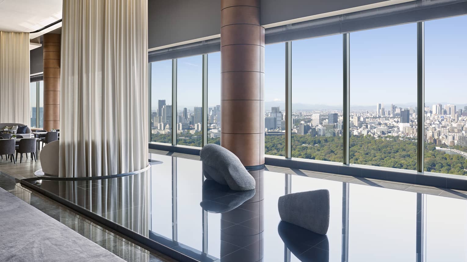 Hotel lounge featuring a calming indoor pond installation and wall of windows