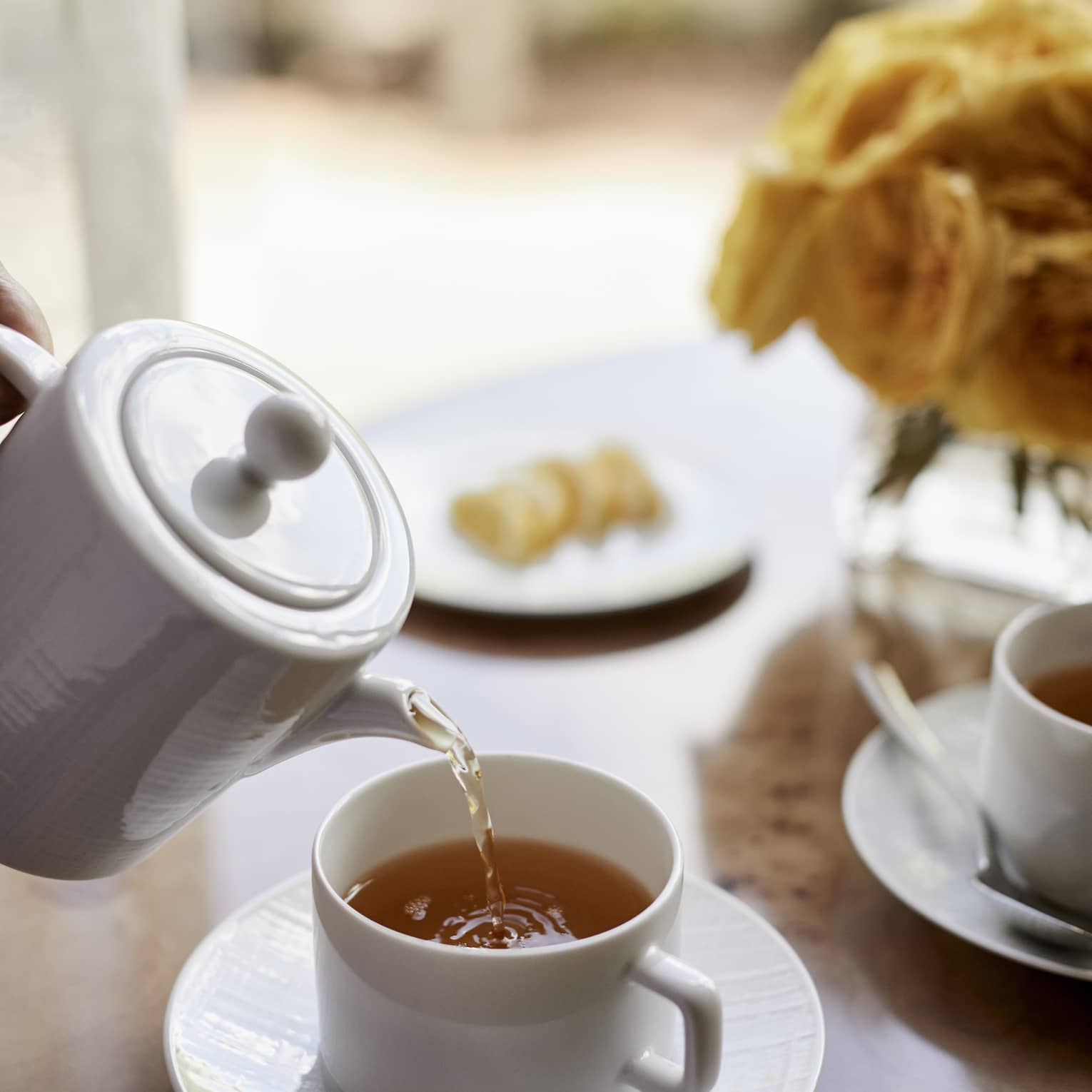 Close-up of tea being poured into white cup