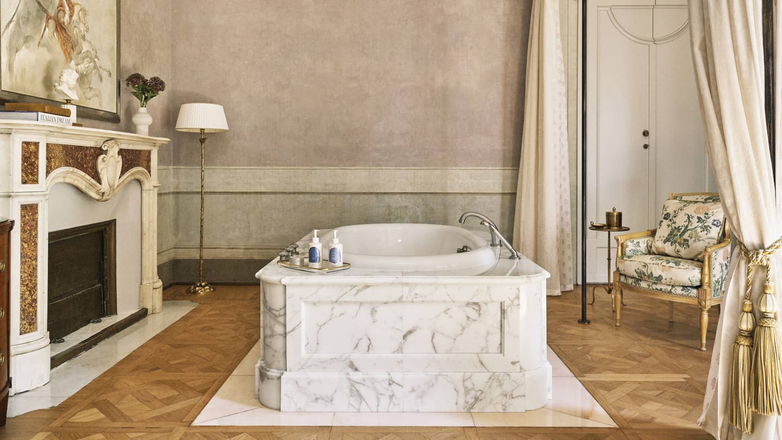 Renaissance Suite with marble tub set in the middle of a room by a grand fireplace, at Four Seasons Hotel Florence