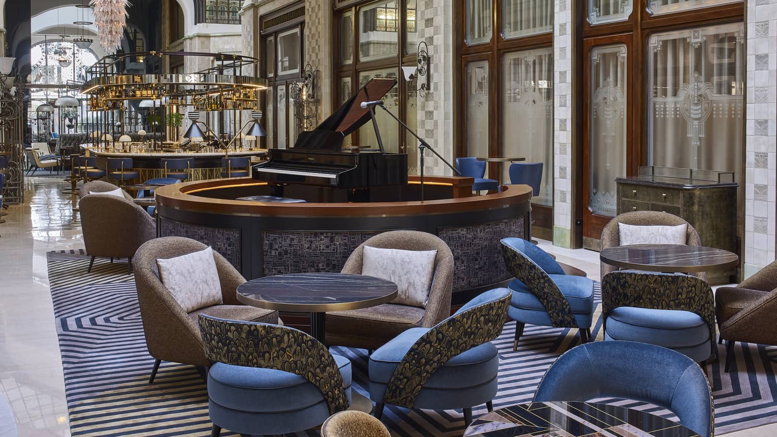 Modern lobby bar and lounge, brown leather and blue chair pairs, grand piano in center