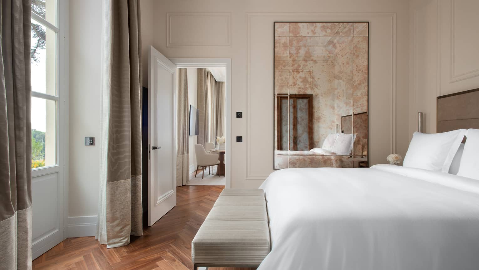 Bedroom with king bed, floor length mirror, parquet floors