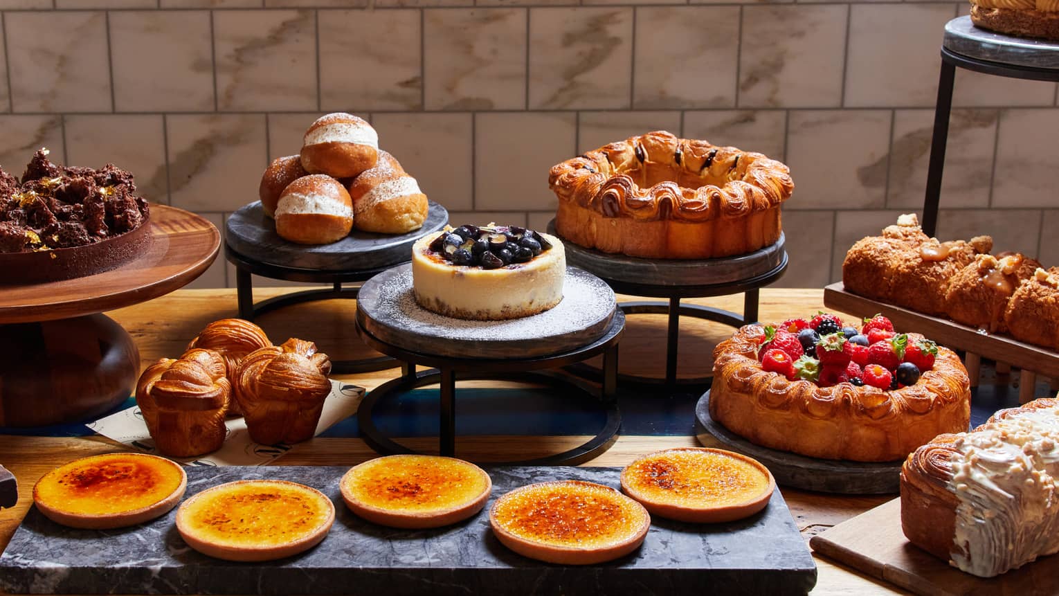 Sunday brunch dessert spread, including cakes brioches, flan and sweet rolls