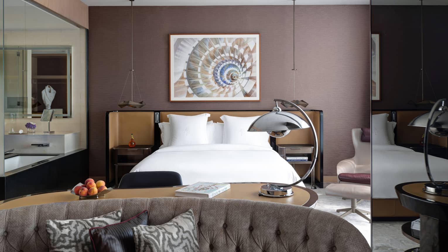 Bedroom with brown wall, artwork, king bed and sitting area