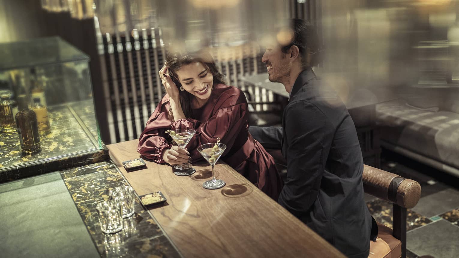 Laughing couple enjoys martinis at The Lounge 
