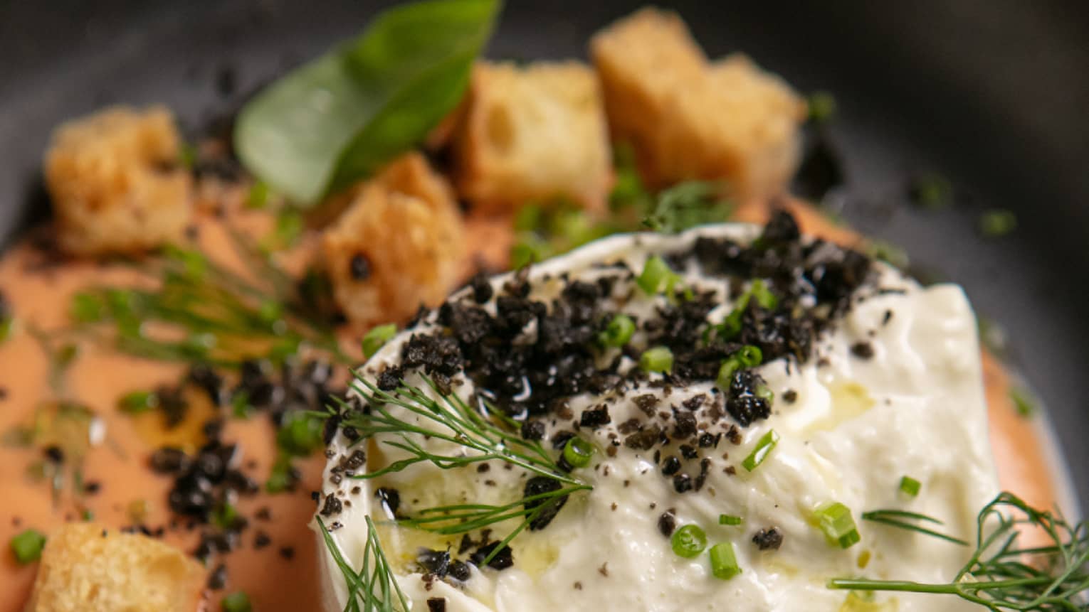 Orange and white food in a black bowl.