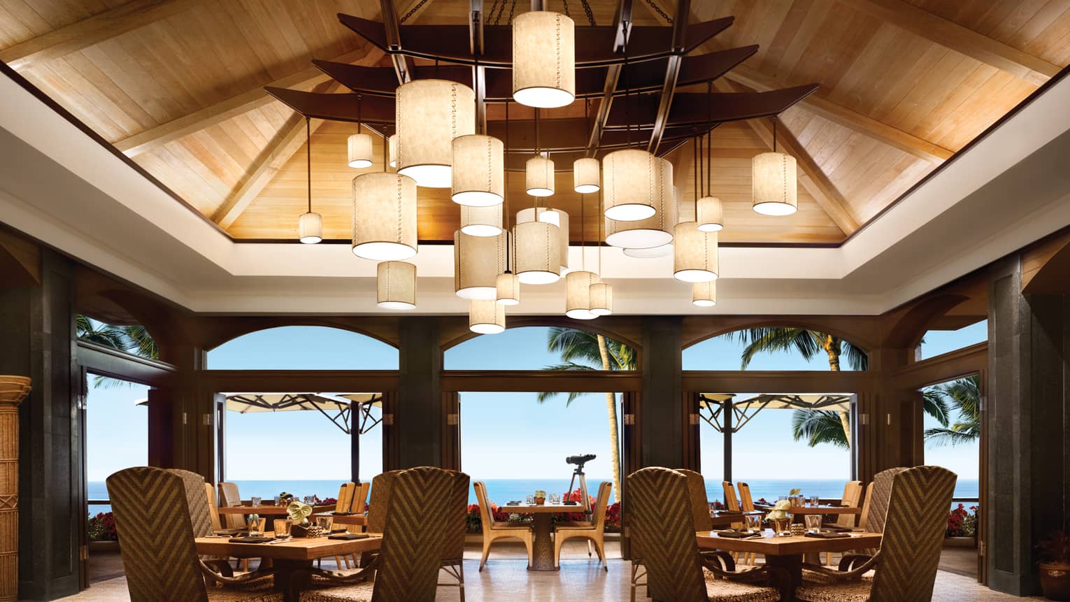 Views Restaurant dining room, tables and chairs under vaulted ceilings with modern lanterns