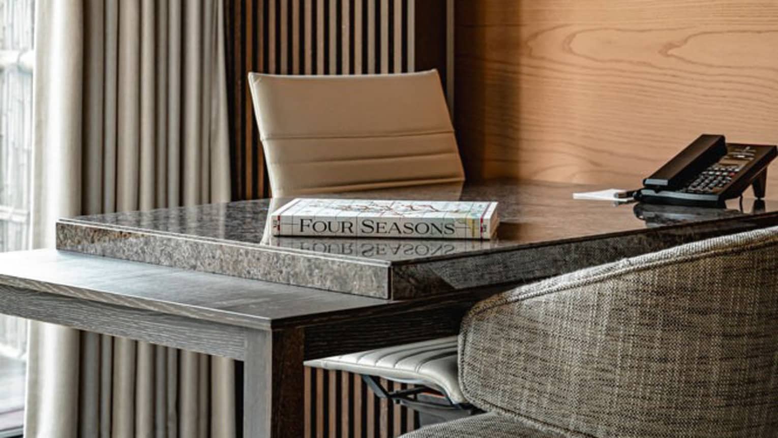 Premier hotel room workspace with a modern desk, chair and a Four Seasons magazine