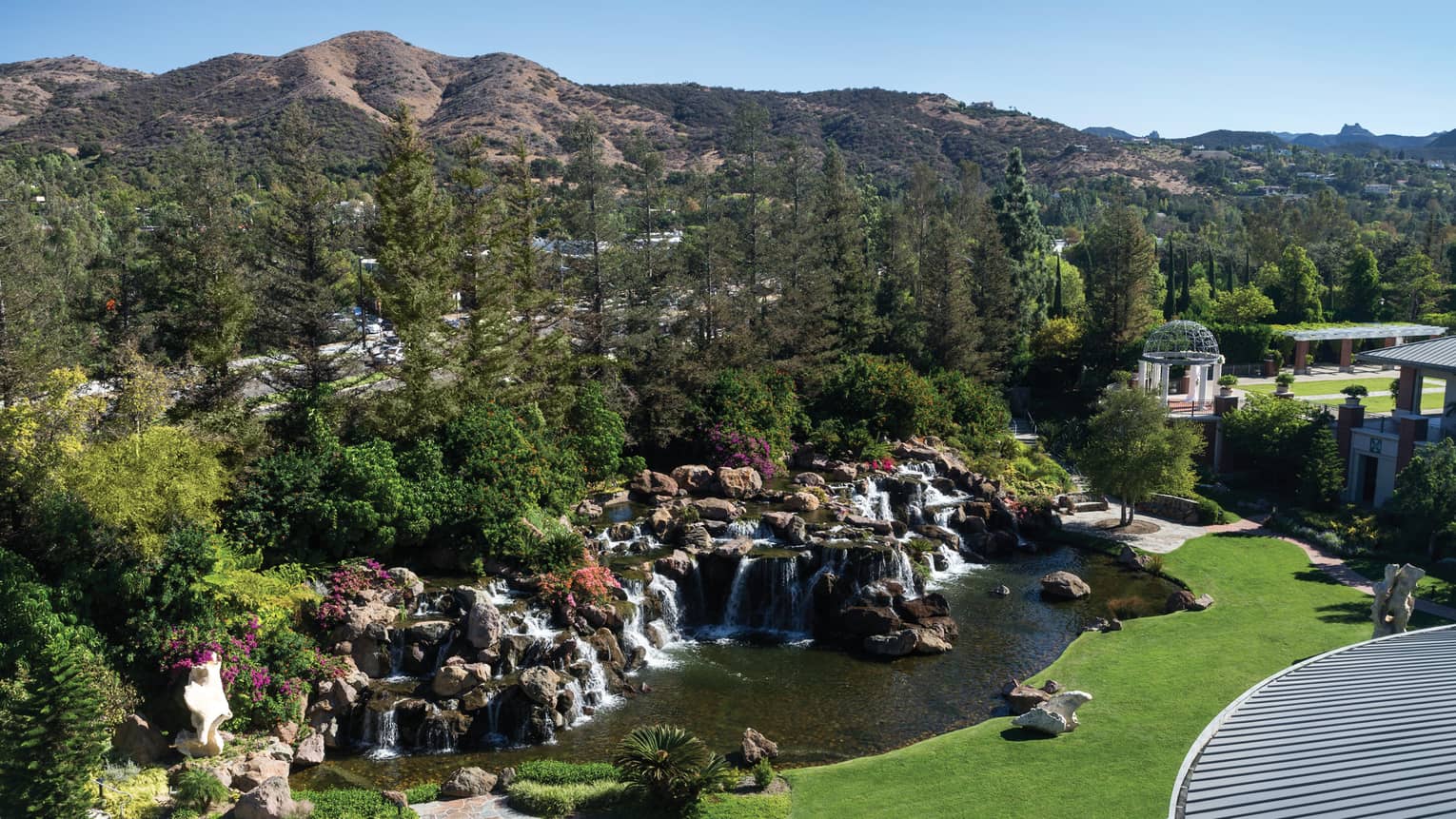 Waterfall Suite view of rocks, waterfalls in front of forest, rolling green hills