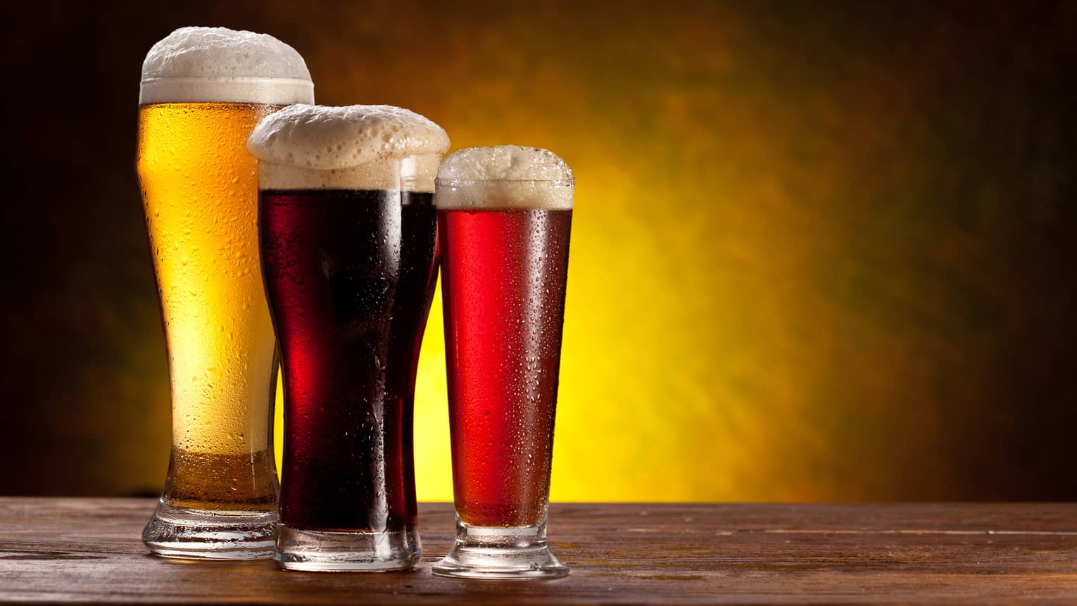 Three glasses of beer of varying colours.