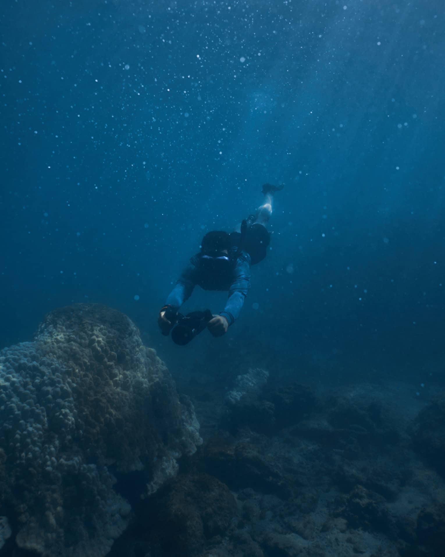 Person diving beneath the water using dive scooter