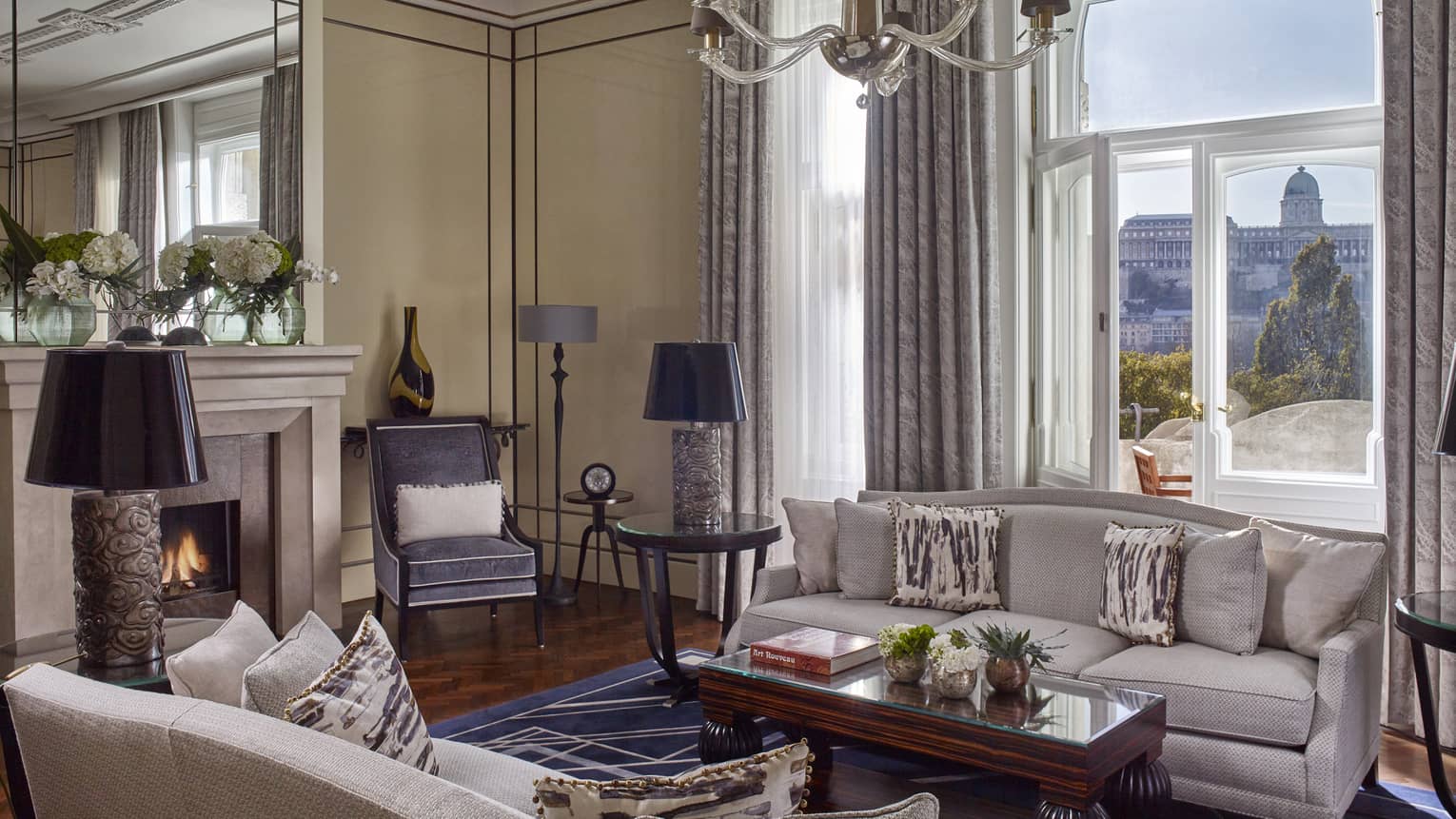 Royal Suite seating area with sofas, fireplace by large sunny window