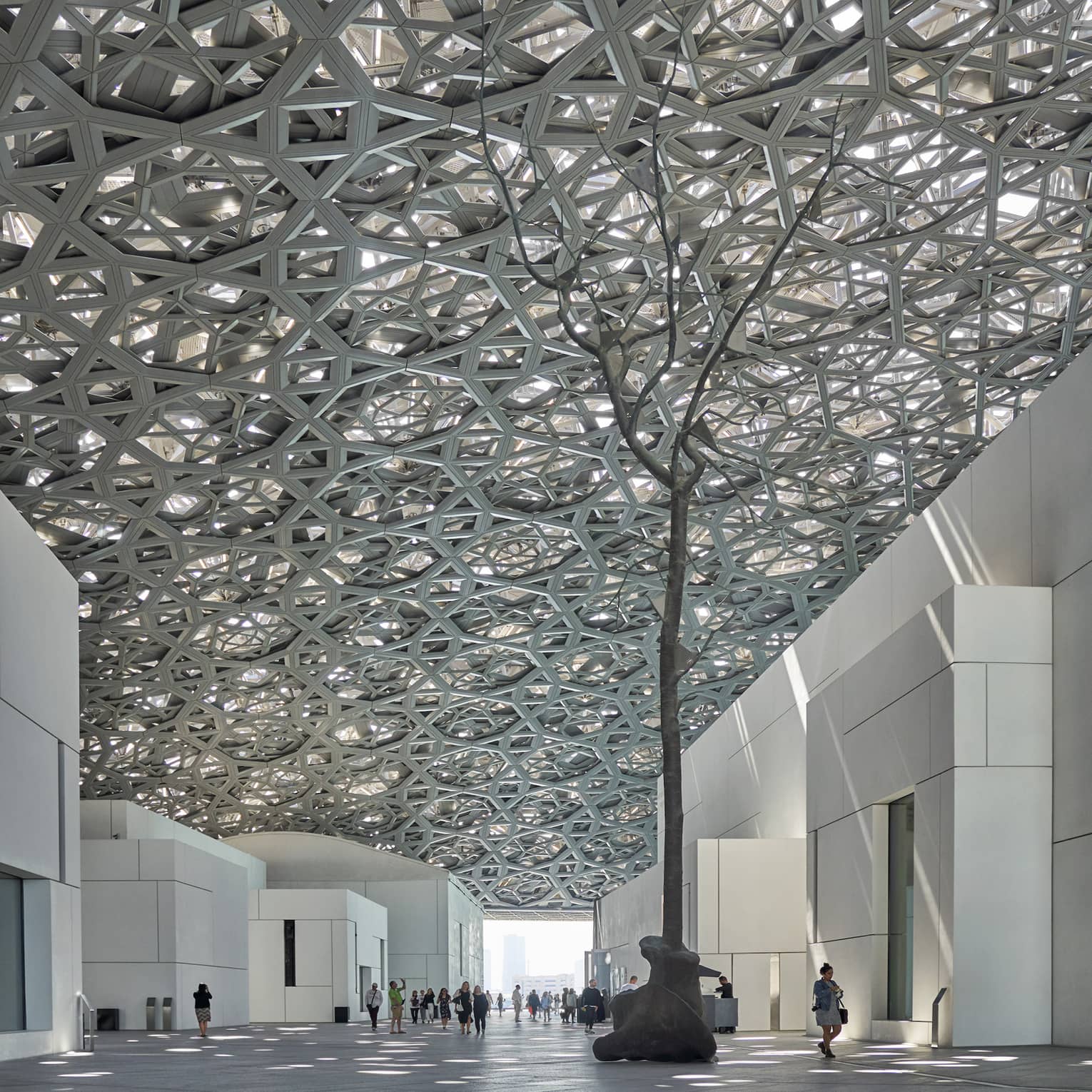 A large sculpture inside of a white stone building.