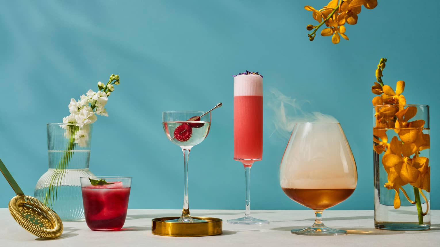 Assorted summer cocktails available at One-Ninety Bar with blue background