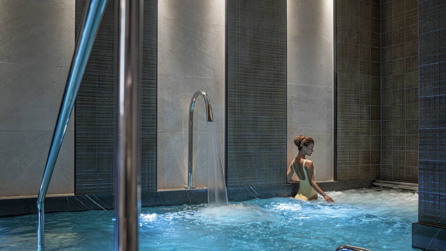 Woman in yellow bathing suit soaks in the Spa's vitality pool