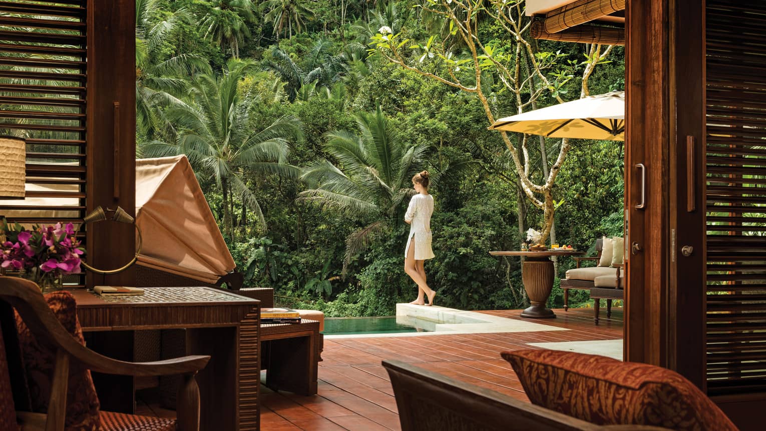Woman stands at side of plunge pool in private villa