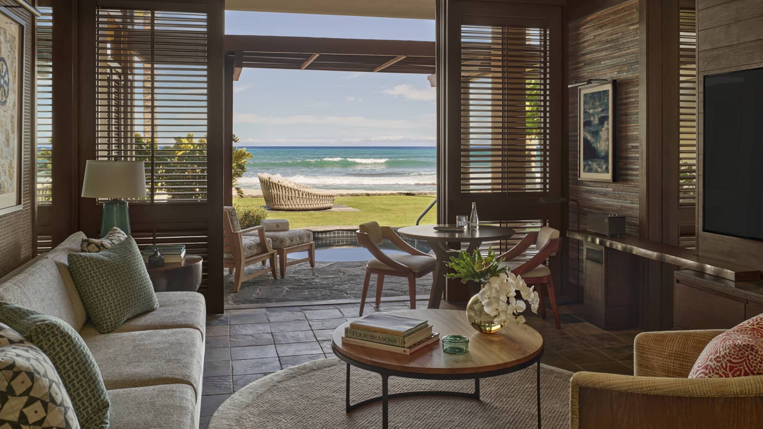Living room in resort suite, opening to private terrace with ground-level beach view