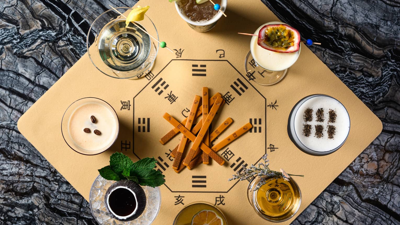 Aerial view of eight cocktails artfully arranged on square wooden board