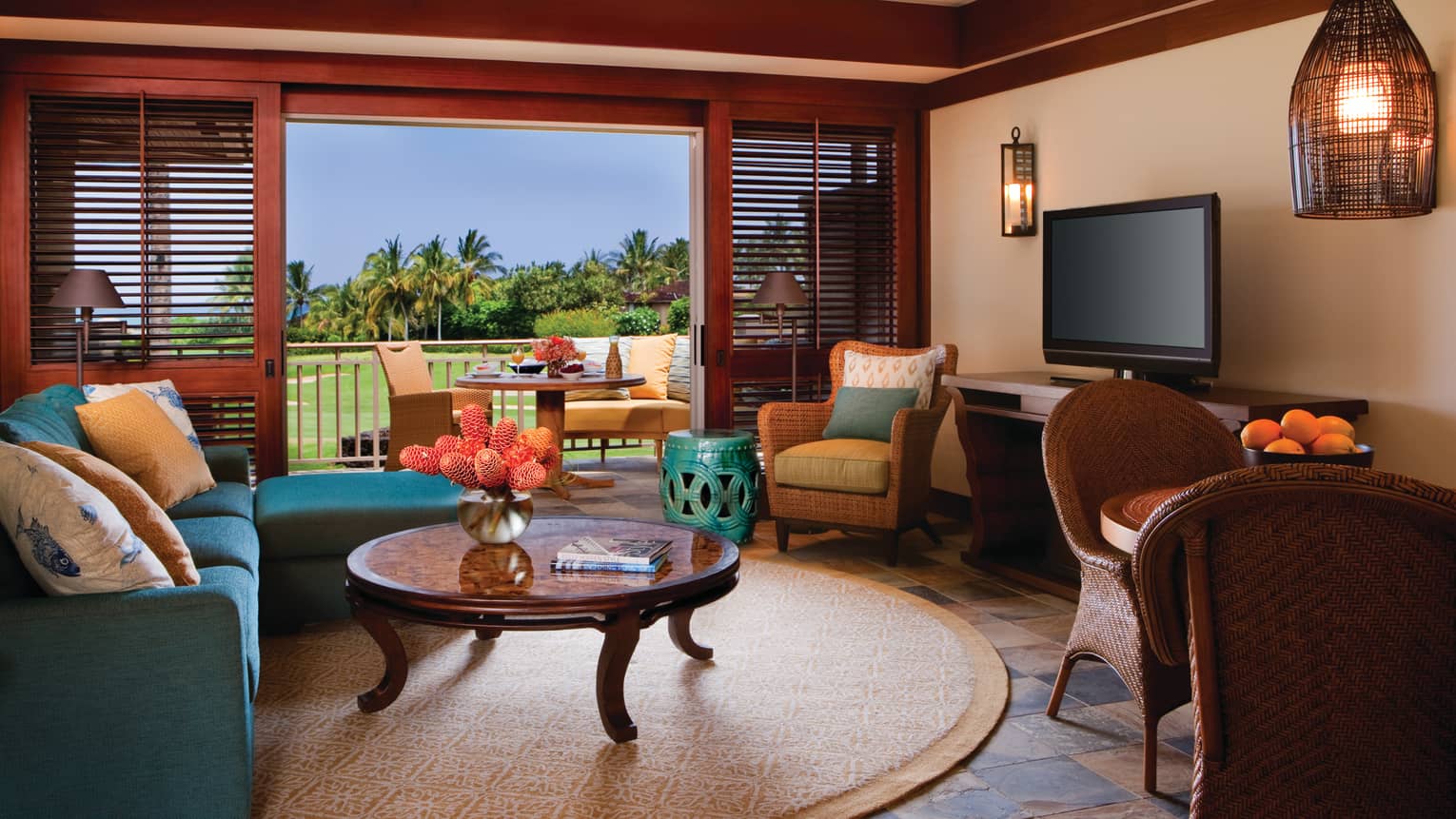 Superior Suite L-shaped blue sofa, round table and carpet, open wall to sunny patio