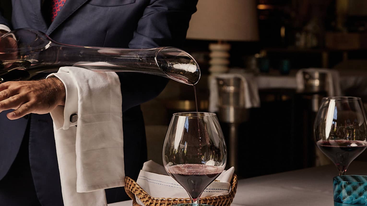 A team member pouring a glass of wine.