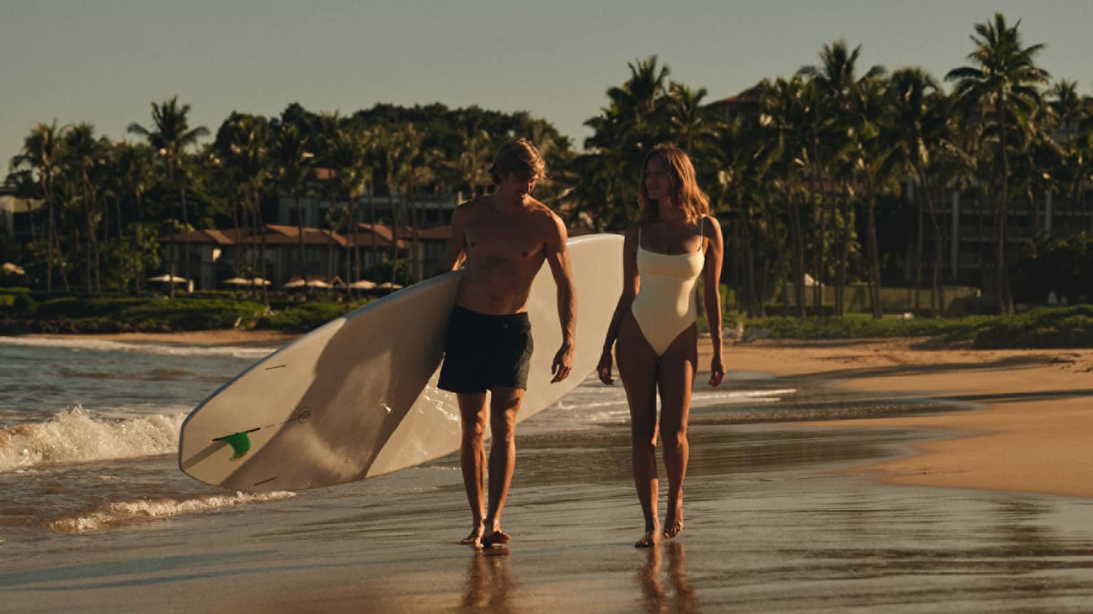 Two surfers walking on the beach