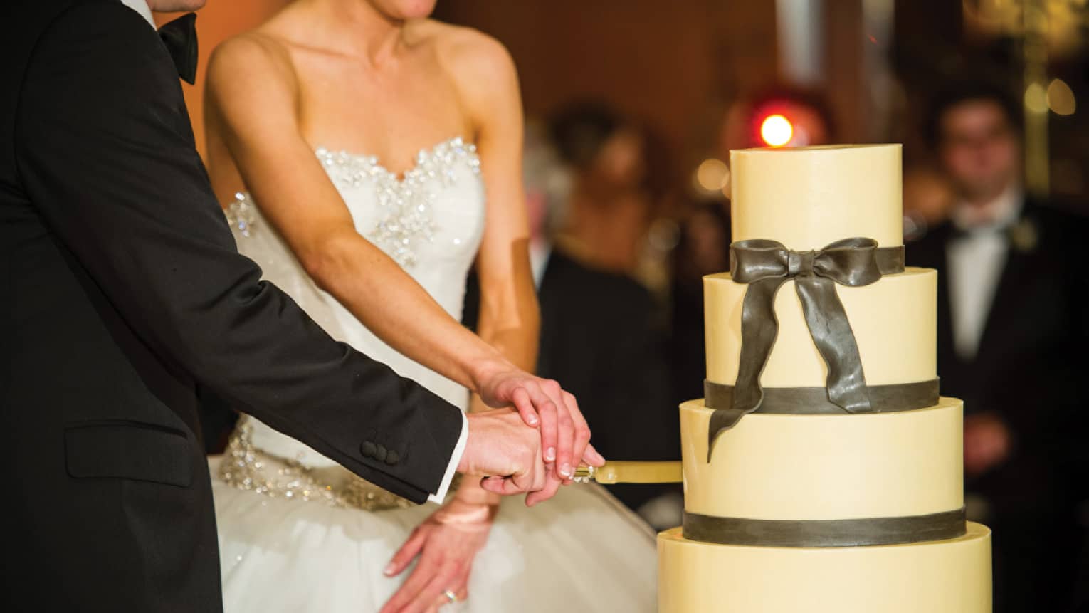 Bride and groom cut four-tiered wedding cake