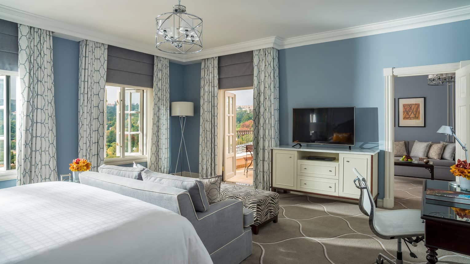 Panoramic View Premier Room corner picture windows, curtains, blue walls, loveseat at foot of bed