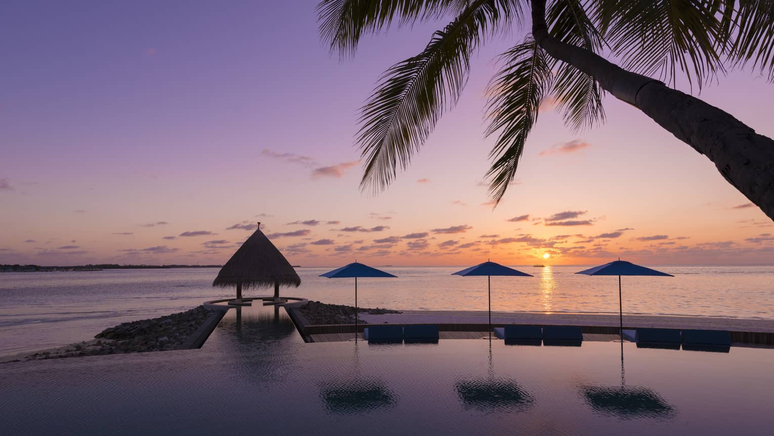 Sunset view of outdoor infinity pool near the beach