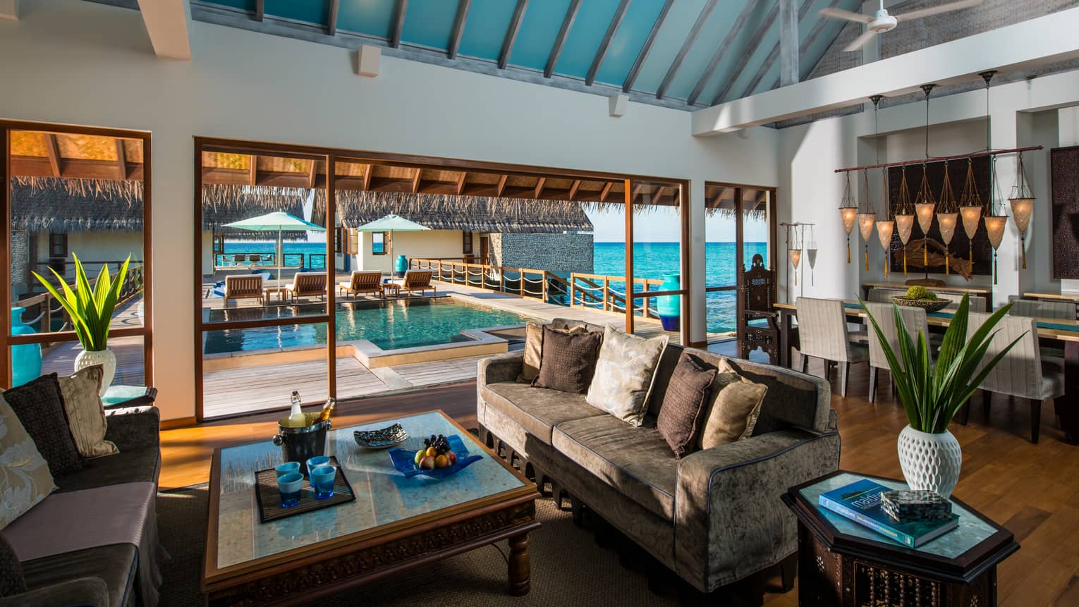 Three-Bedroom Land and Ocean Suite living room sofas around table with fresh fruit, beer on ice