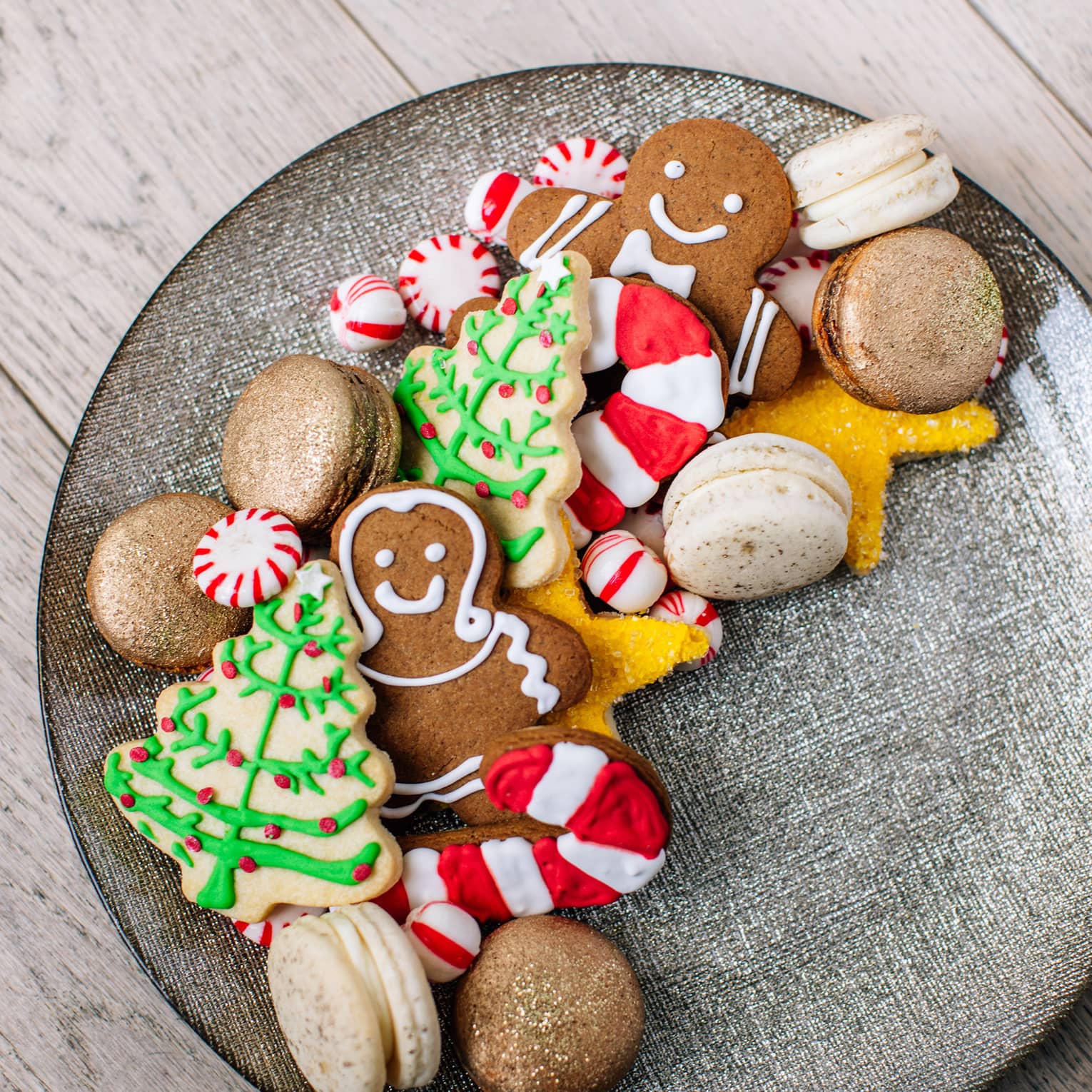 A plate of holiday sugar cookies – christmas trees and ginger bread men and candy canes