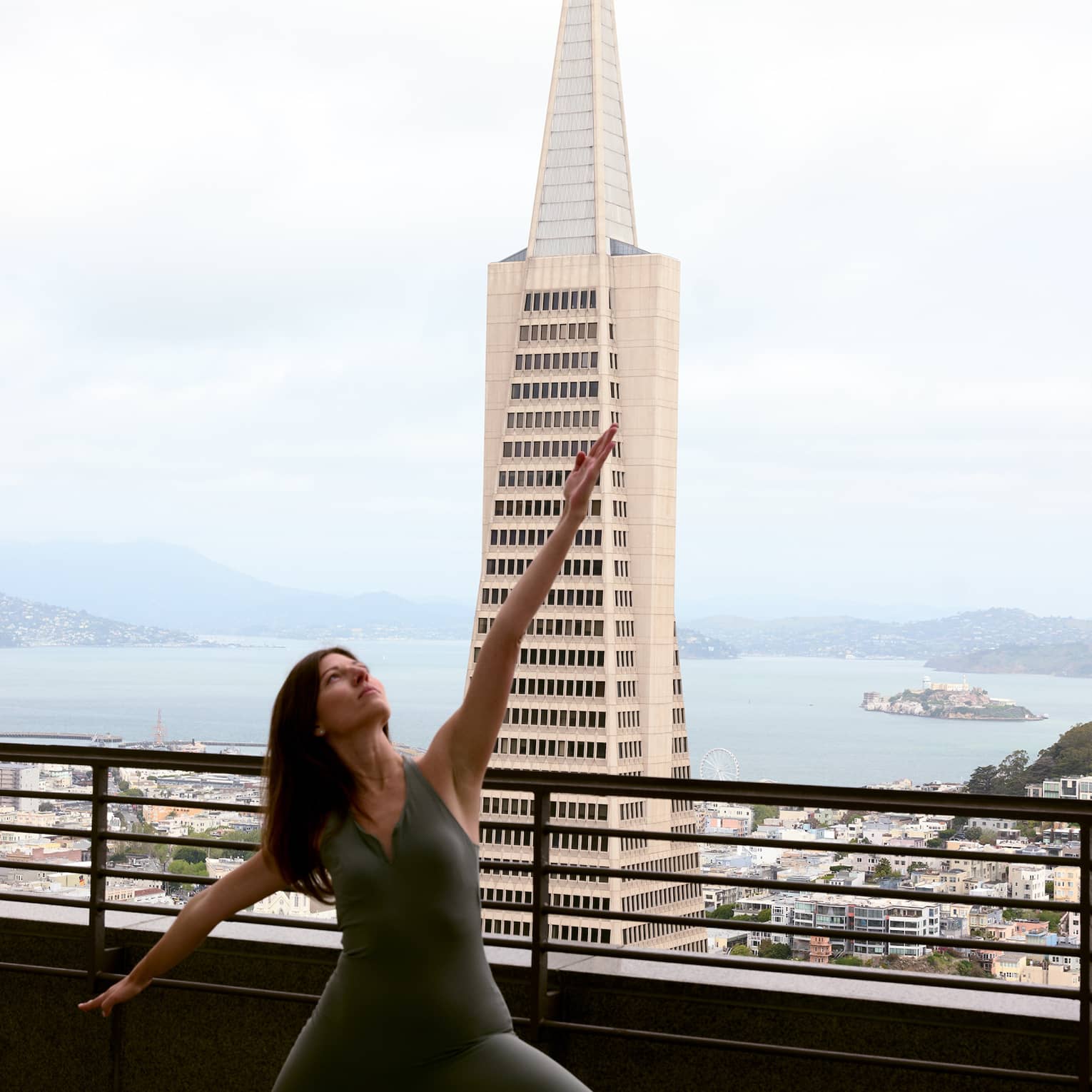 A person doing yoga on a rooftop with the city in the background