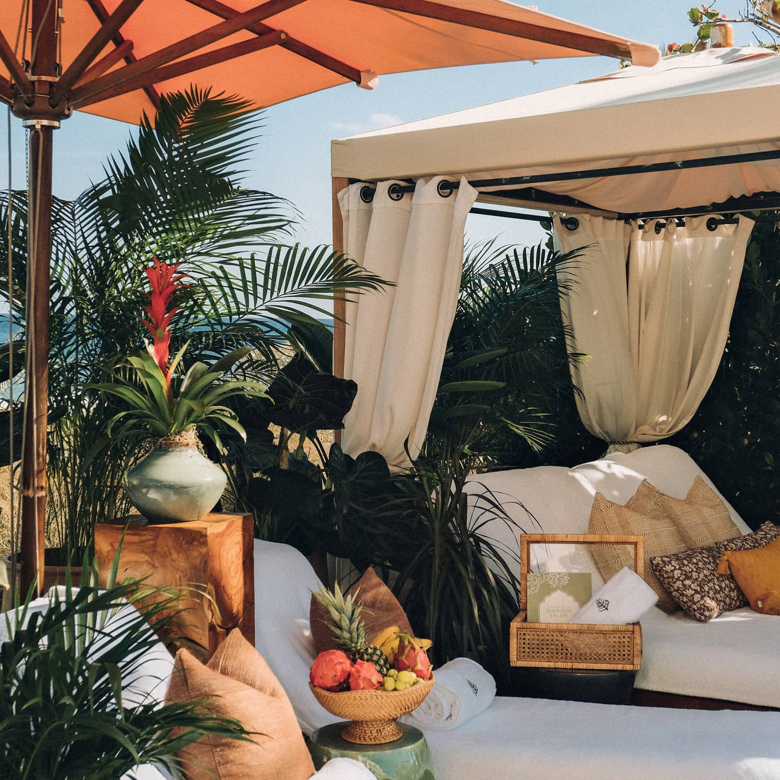 Lounge chairs with an umbrella and a cabana near the pool