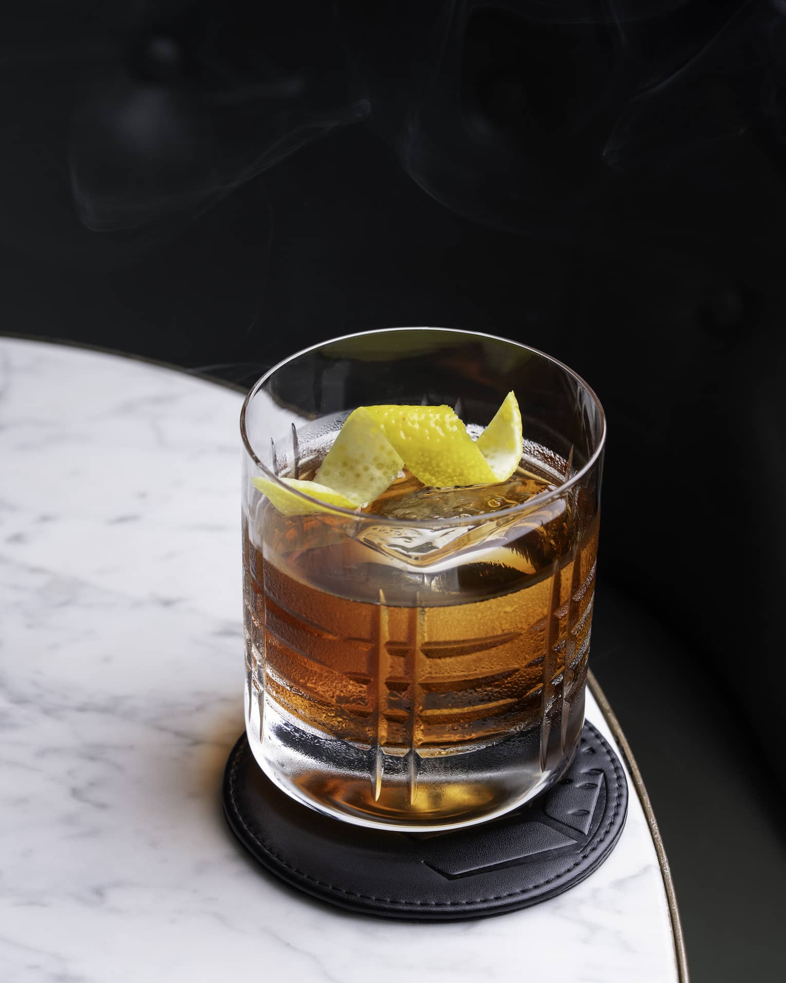 Old Fashioned cocktail on a marble table