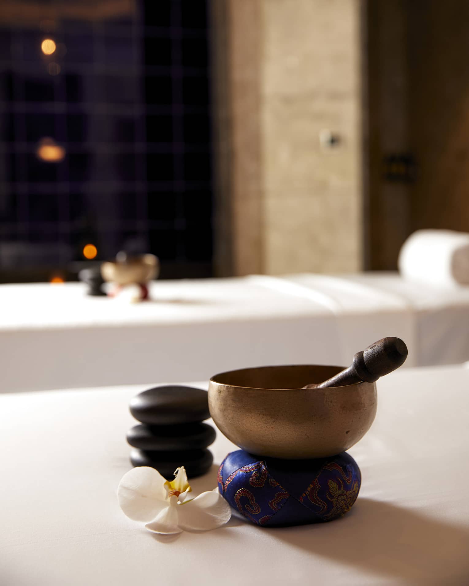 Copper bowl and wood spoon on couples spa treatment beds in spa