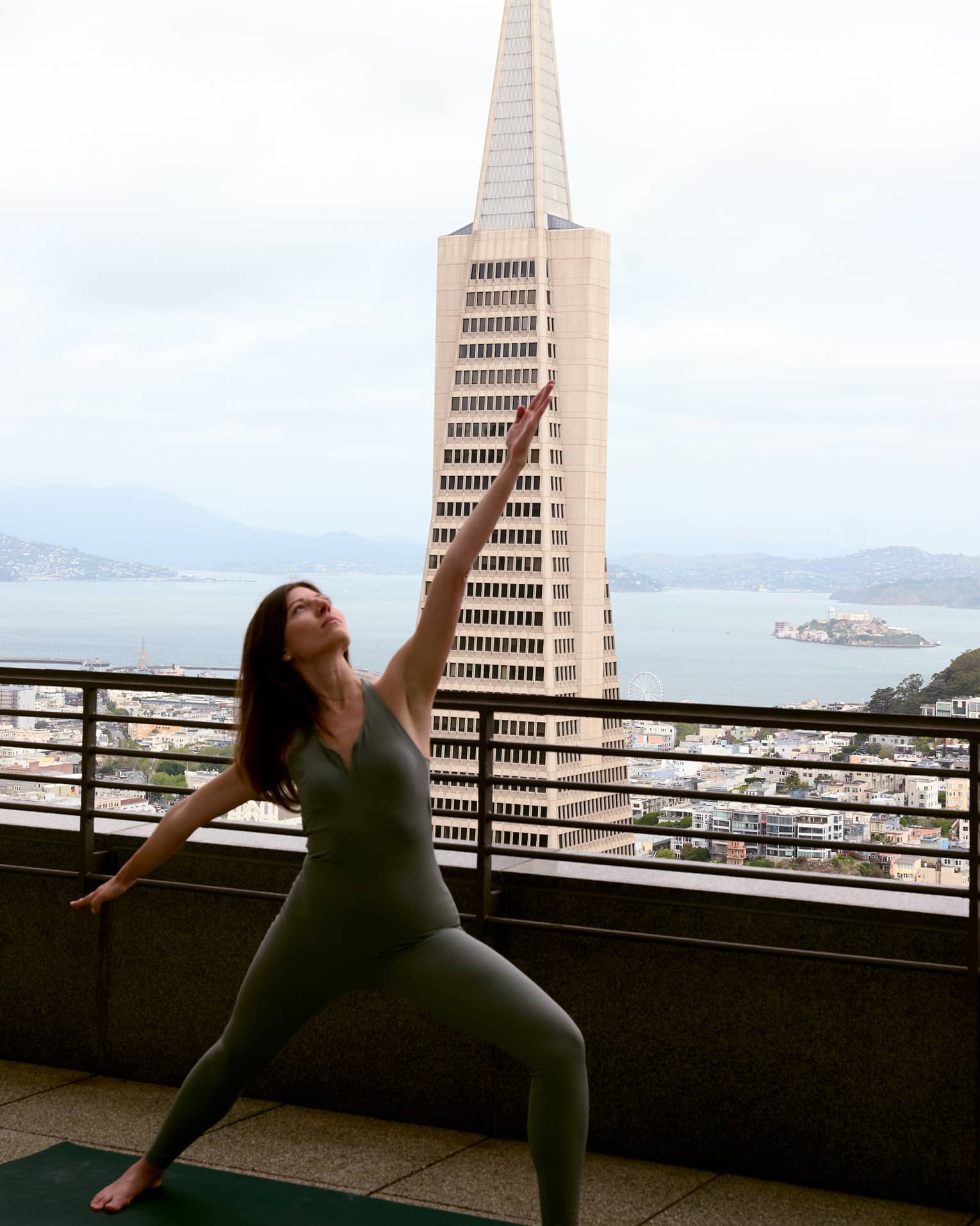 A person doing yoga on a rooftop with the city in the background