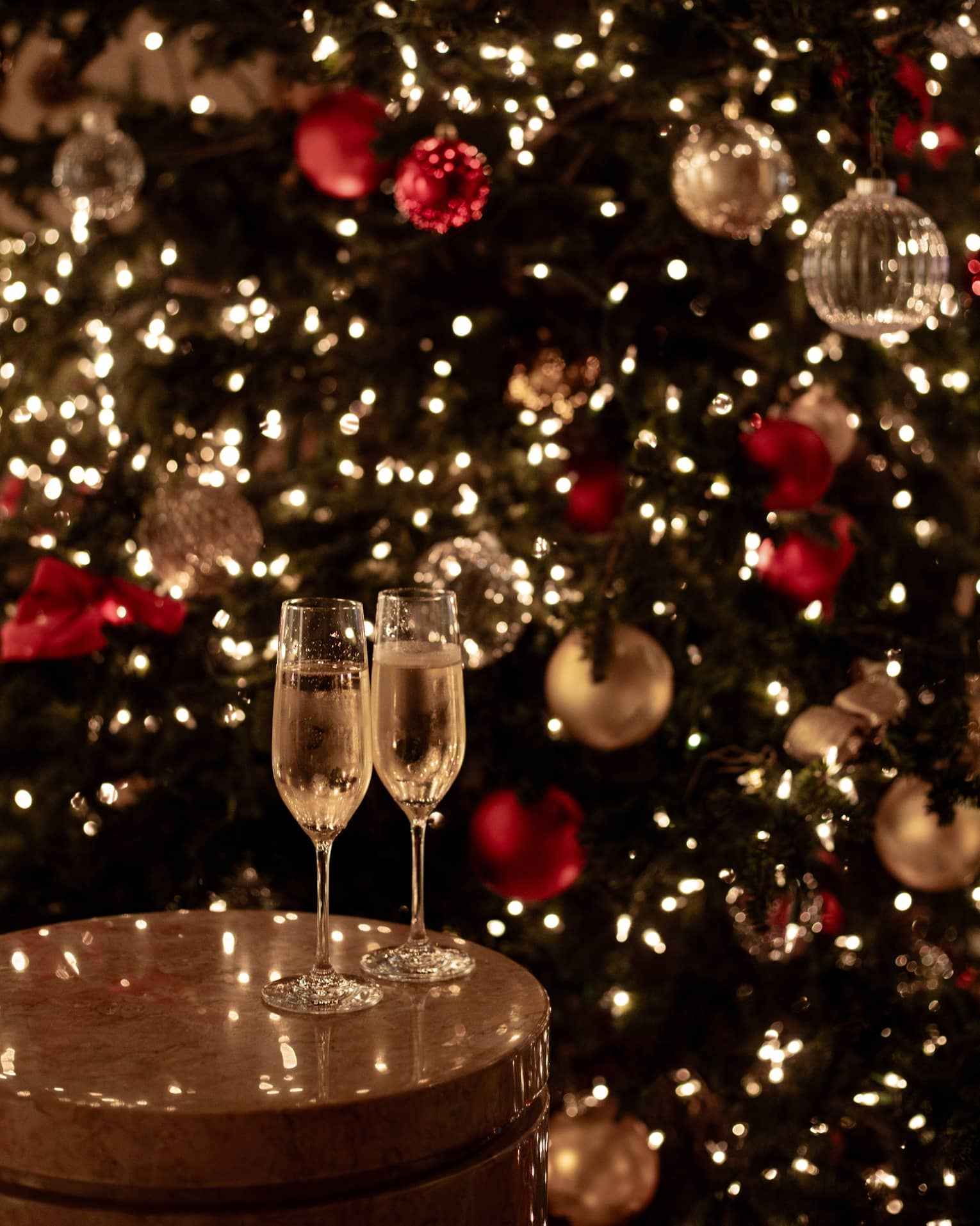 Joyous champagne toast with festive lights for Tokyo Christmas and New Year’s Eve celebrations.