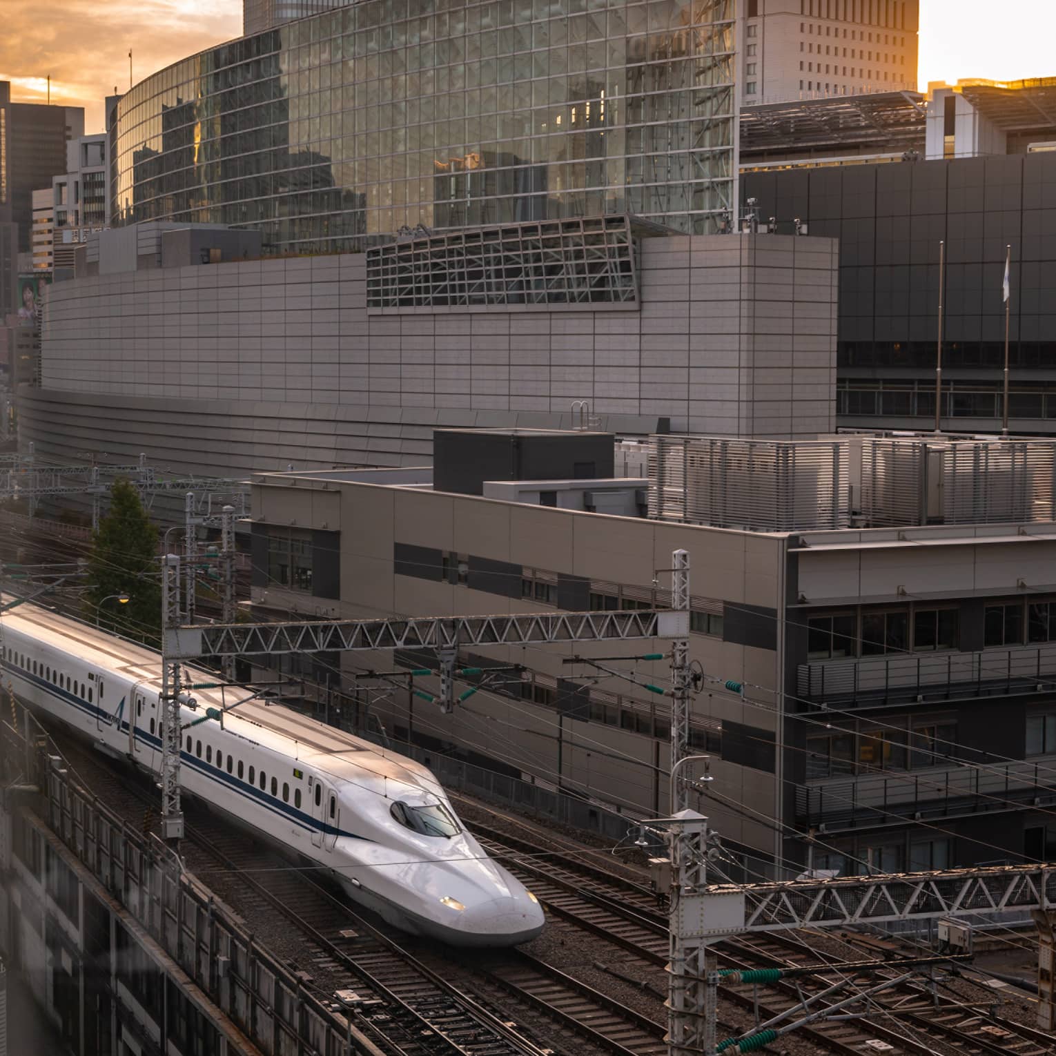 Shinkansen bullet train arrives at the station at sunset